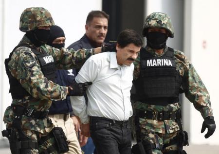 Foto de archivo en la que se ve al capo del narcotráfico Joaquín "El Chapo" Guzmán siendo escoltado por soldados en el aeropuerto de la Ciudad de México, 22 de febrero de 2014. Estados Unidos solicitó formalmente a México la extradición del capo mexicano Joaquín "El Chapo" Guzmán en junio, semanas antes de que el narcotraficante de más alto perfil se fugara de un penal de máxima seguridad en el centro del país, dijo la fiscal general. REUTERS/Edgard Garrido