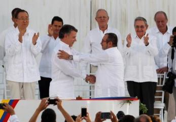 Foto del lunes del presidente de Colombia, Juan Manuel Santos (I), y el líder de las FARC, Timochenko, estrechando sus manos tras firmar el acuerdo de paz en Cartagena