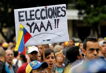 Una manifestante sostiene un cartel pidiendo elecciones de inmediato en Venezuela, en medio de una protesta en Caracas contra el Gobierno del presidente Nicolás Maduro. Foto de archivo.