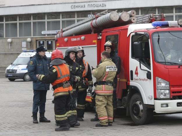 Members of Emergency services stand outside Sennaya Ploshchad metro station in St. Petersburg