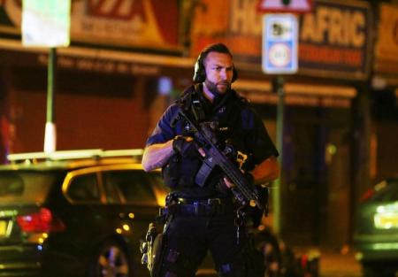 Un policía armado vigila el lugar donde un vehículo arrollo a personas en el barrio de Finsbury Park en Londres.